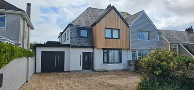 a large wooden house with a garage at Luxury home near Fistral Beach in Newquay