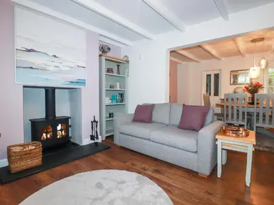a living room with a couch and a fireplace at Still Waters in St Austell