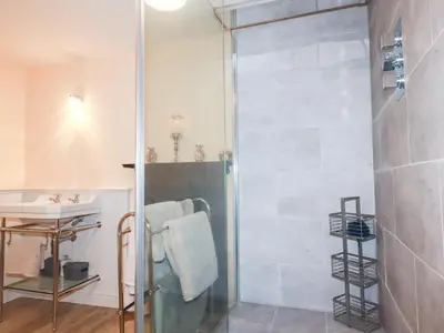 a shower with a glass door in a bathroom at Still Waters in St Austell