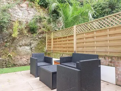 a group of chairs sitting next to a fence at Still Waters in St Austell