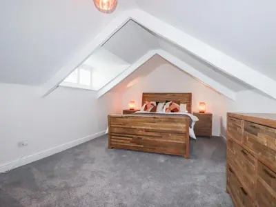 a bedroom with a bed in a attic at Still Waters in St Austell