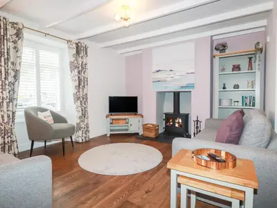 a living room with a couch and a tv at Still Waters in St Austell