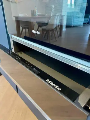 a display drawer of a tv with a table in a room at Shoreline - one of the best views? in Carbis Bay