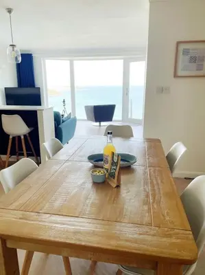 a wooden table with a bottle of wine on it at Shoreline - one of the best views? in Carbis Bay