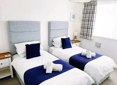 a bedroom with two beds with towels on them at Shoreline - one of the best views? in Carbis Bay