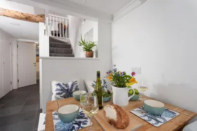 a dining room with a wooden table with blue bowls at Shell Cottage, St Ives in St Ives
