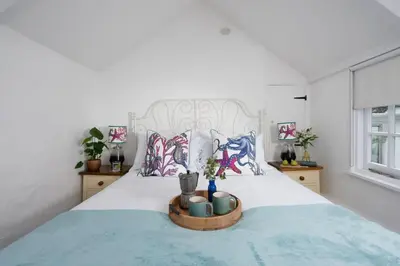 a bedroom with a large bed with a tray on it at Shell Cottage, St Ives in St Ives