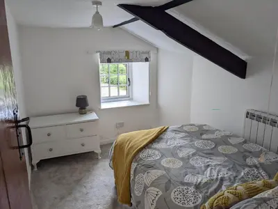a bedroom with a bed and a window at Foxglove Cottage in Launceston