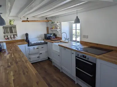 a kitchen with white cabinets and a black stove top oven at Foxglove Cottage in Launceston