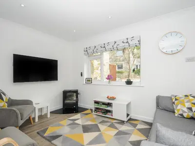 a living room with a couch and a tv at Wheal Charlotte Cottage in Penzance