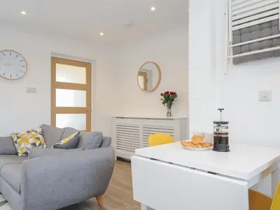 a living room with a couch and a table at Wheal Charlotte Cottage in Penzance