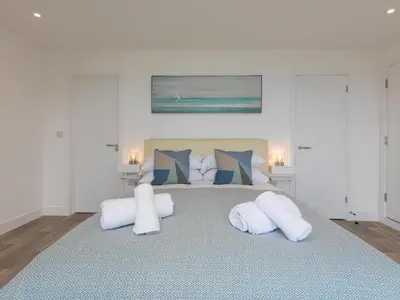 a bedroom with a large bed with two white pillows at Samphire in St Ives