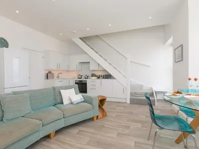 a living room with a couch and a table at Samphire in St Ives