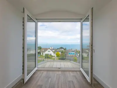an empty room with sliding glass doors with a view at Samphire in St Ives