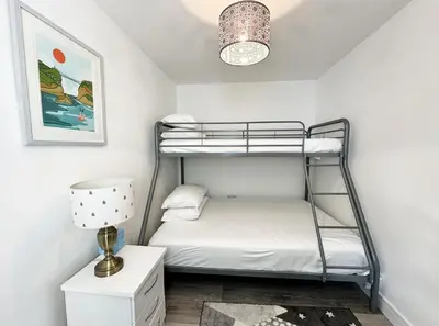 a bedroom with a bunk bed and a lamp at The Cottage Annex in Newquay