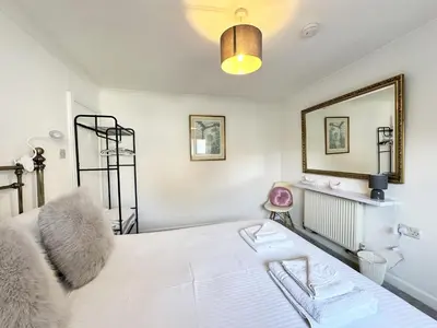 a bedroom with a bed and a mirror at The Cottage Annex in Newquay