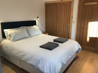 a bedroom with a bed with two towels on it at Hendra Retreat Piglets Cottage North Cornwall in Camelford
