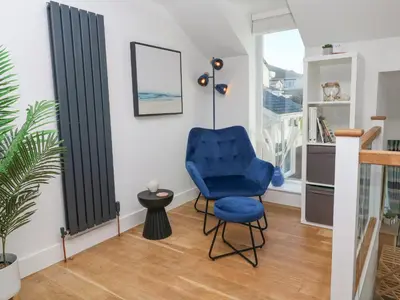 a blue chair in a room with a window at Island View in Newquay