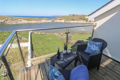 a balcony with two chairs and a table with a view at Island View in Newquay