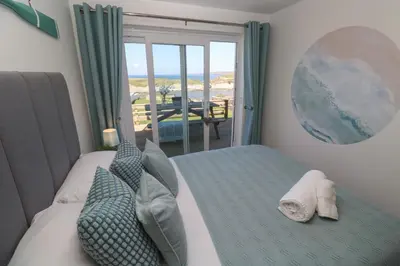 a bedroom with a bed with a view of the ocean at Island View in Newquay