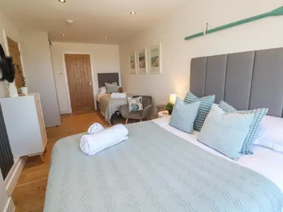 a bedroom with a large bed with blue pillows at Island View in Newquay