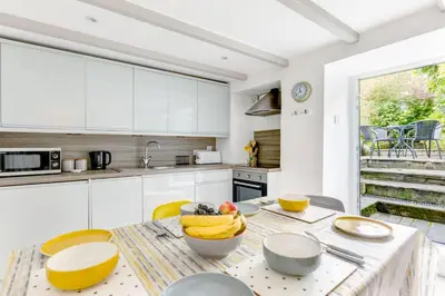 a kitchen with a table with a bowl of bananas on it at Stokes Cottage in Wadebridge