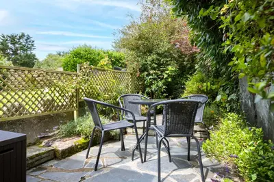 three chairs and a table on a patio at Stokes Cottage in Wadebridge