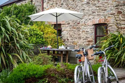 two bikes parked next to a table with an umbrella at Wheal Kitty nr Truro in Truro