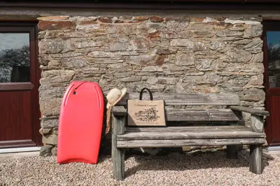 a red suitcase sitting next to a wooden bench at Wheal Kitty nr Truro in Truro