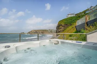a hot tub with a view of the ocean at Award Winning 5* BEACH HOUSE! Hot Tub & Fire Pit in Portreath