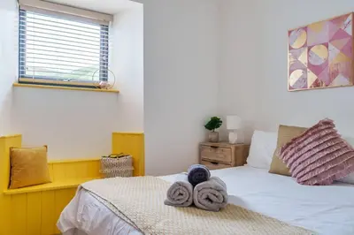 a bedroom with a bed with towels on it at Award Winning 5* BEACH HOUSE! Hot Tub & Fire Pit in Portreath