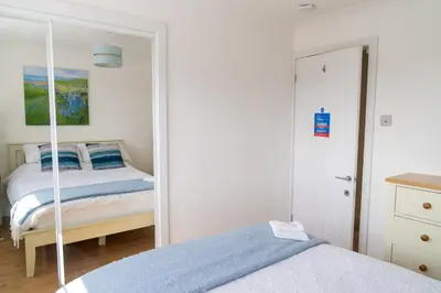 a bedroom with a mirror next to a bed at Trethvor House FREE PARKING Private bathroom Double in Padstow