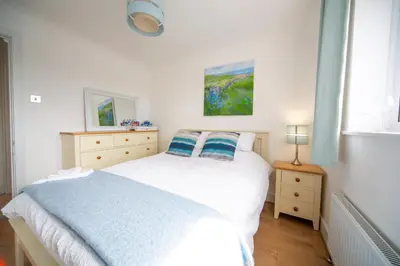 a bedroom with a bed and two dressers and a window at Trethvor House FREE PARKING Private bathroom Double in Padstow