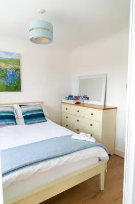 a bedroom with a bed and a dresser with a mirror at Trethvor House FREE PARKING Private bathroom Double in Padstow