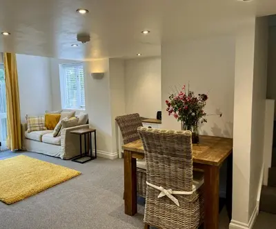 a living room with a table and chairs and a couch at The Coach House - with hot tub in St Austell
