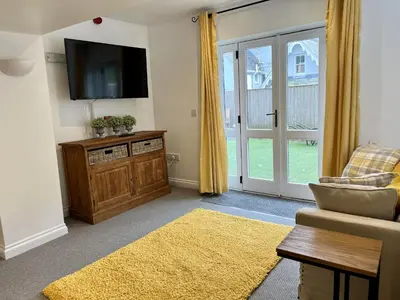 a living room with a television and a couch at The Coach House - with hot tub in St Austell