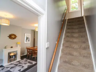 a staircase in a home with a living room and a table at 8 Rosewall Cottages in St Ives