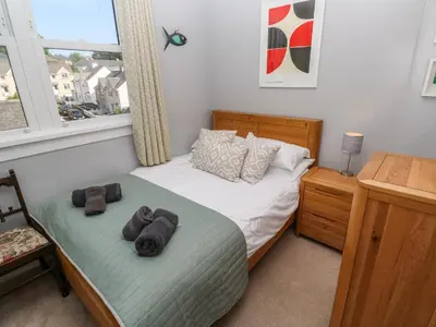 a bedroom with a bed with towels on it at 8 Rosewall Cottages in St Ives