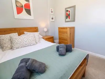 a bedroom with a large bed with blue towels on it at 8 Rosewall Cottages in St Ives