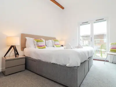a bedroom with a large bed with white sheets and pillows at Garras in Truro