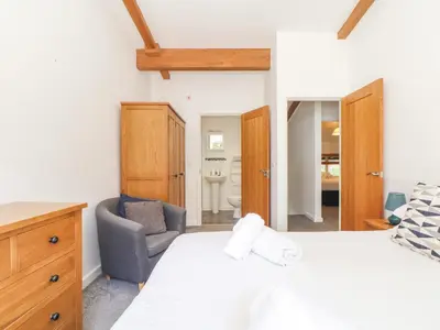 a bedroom with a bed and a chair and a mirror at Tehidy in Truro
