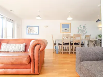 a living room with a couch and a dining room at Tehidy in Truro