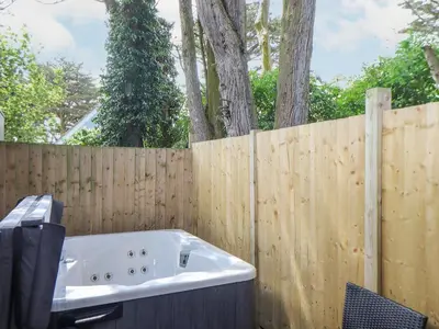 a bath tub sitting next to a wooden fence at Tehidy in Truro