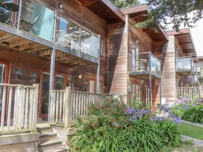 a wooden house with a balcony and flowers at Tehidy in Truro