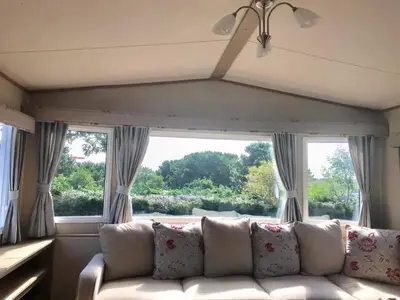 a living room with a couch and a large window at Newquay Cornwall Holiday Rental in Newquay