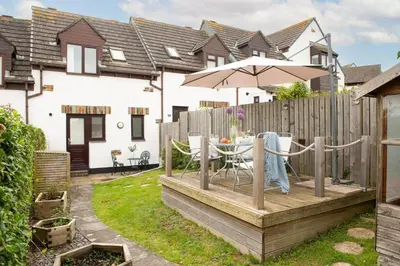a backyard with a table and an umbrella at Sunshine Cottage, Padstow in Padstow