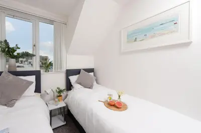 a bedroom with two beds with a tray of fruit at Sunshine Cottage, Padstow in Padstow