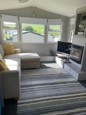 a living room with a couch and a flat screen tv at 93 Newquay Bay resort Pet friendly in Newquay