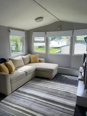 a living room with a couch and two windows at 93 Newquay Bay resort Pet friendly in Newquay
