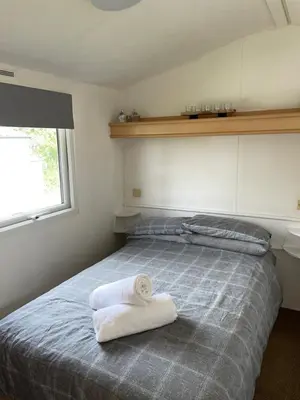 a bedroom with a bed with two towels on it at 93 Newquay Bay resort Pet friendly in Newquay